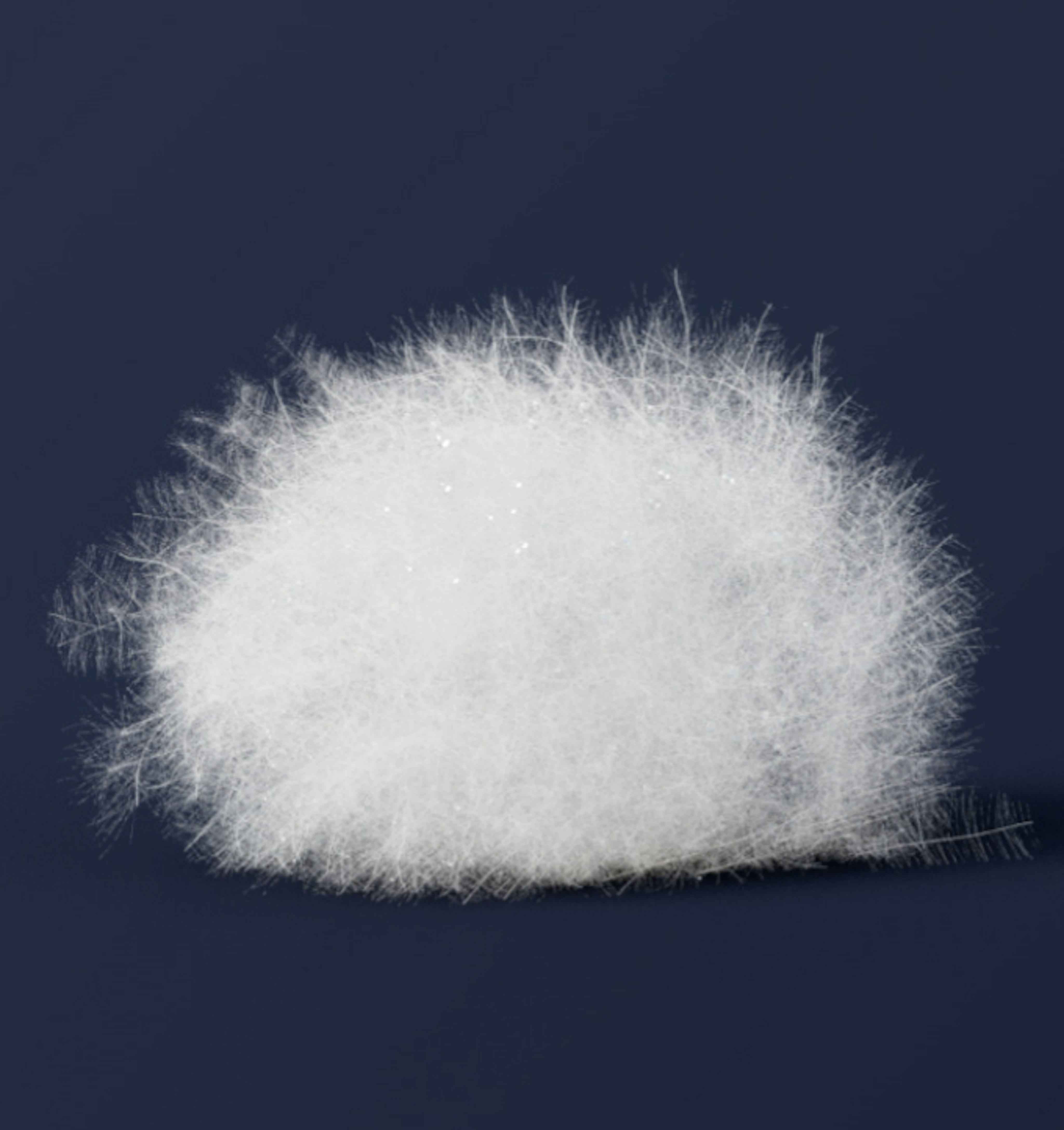 A Mammut dry down jacket showcased with its fluffy white ball of premium down feathers against a dark backdrop.