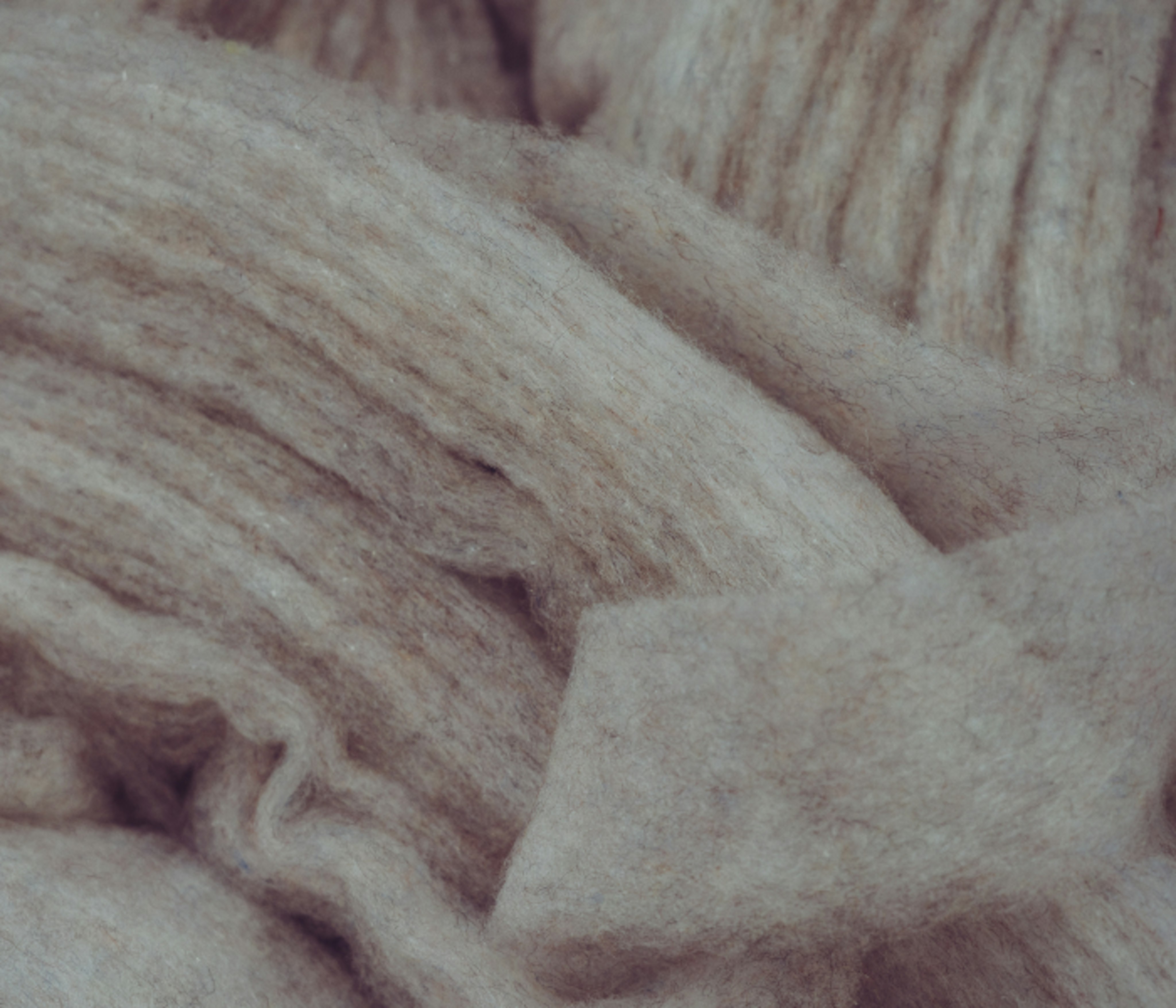 Close-up of Mammut beige wool fabric showcasing its soft texture and natural wrinkles, ideal for high-performance sports and mountaineering gear.